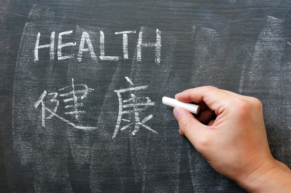 Salud - palabra escrita en una pizarra con una versión china —  Fotos de Stock