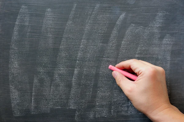 Hand skriva på en suddig tomma tavlan med krita — Stockfoto