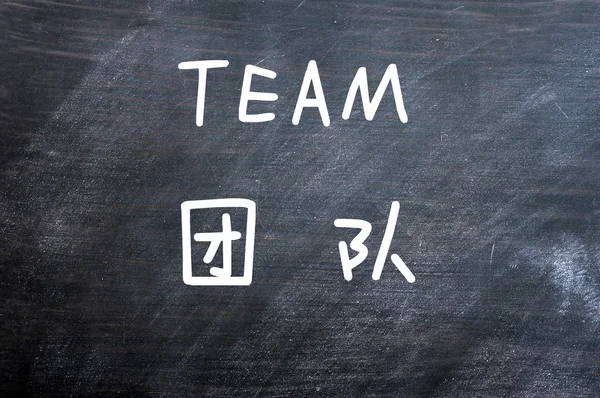 Team - ord skrivet på en suddig svart tavla — Stockfoto