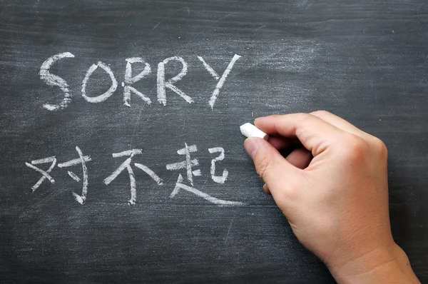 Sorry - woord geschreven op een vlekkerig schoolbord — Stockfoto