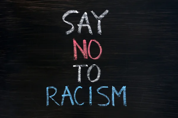 Скажи "нет" расизму, написанному на грязном фоне доски — стоковое фото