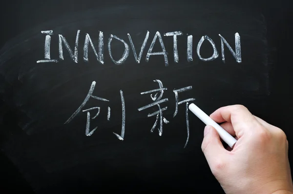 技術革新 - 英語、中国語の白いチョークで書かれた単語 — ストック写真