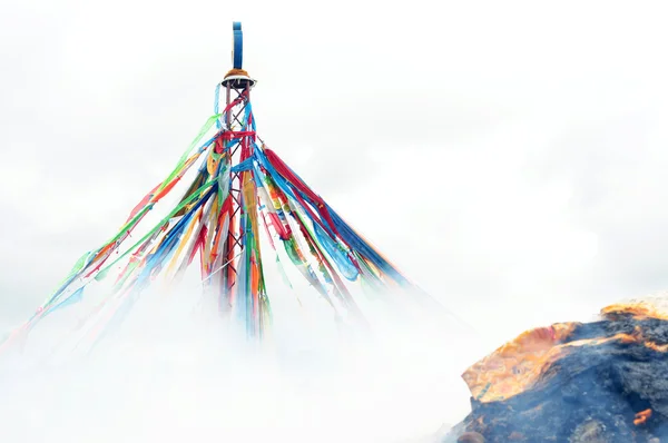 Drapeaux de prière tibétains et rocher mani dans la fumée — Photo