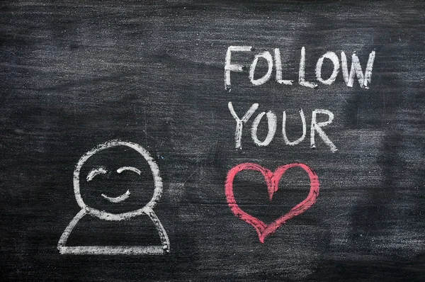 语音泡沫与一个卡通人物，这句话在黑板背景上绘制的"跟随你的心" — 图库照片