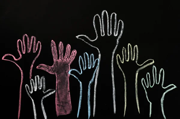 Happy volunteering hands on a blackboard background