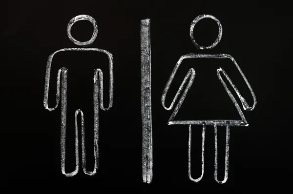 Символы мужчин и женщин на фоне доски — стоковое фото
