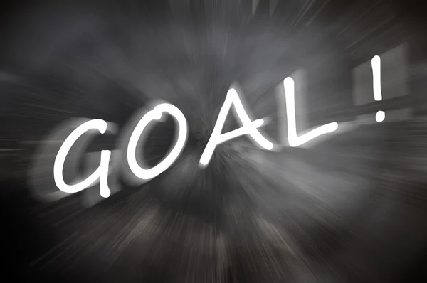 Chalk drawing of "Goal" word written on a blurred chalkboard with motion rays — Stock Photo, Image