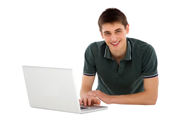 Tonårspojke med laptop liggande — Stockfoto