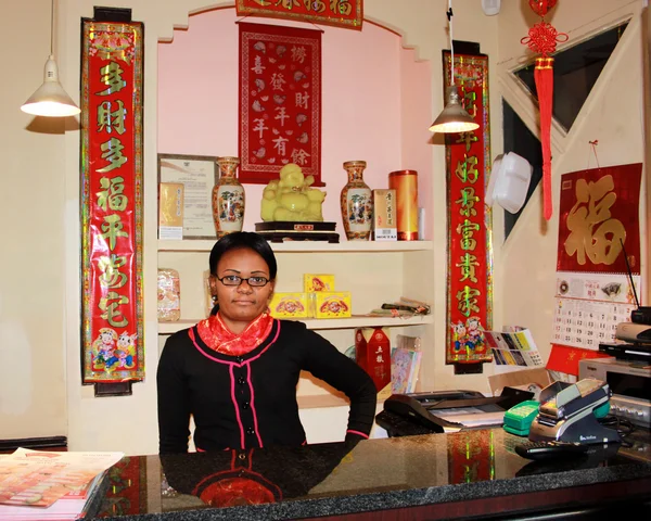 Κινέζικο εστιατόριο αφρικανική ρεσεψιονίστ που παρουσιάζουν — Φωτογραφία Αρχείου