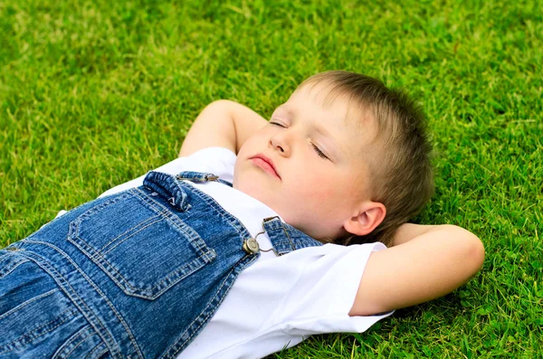Enfant de 4 ans couché sur l'herbe . — Photo