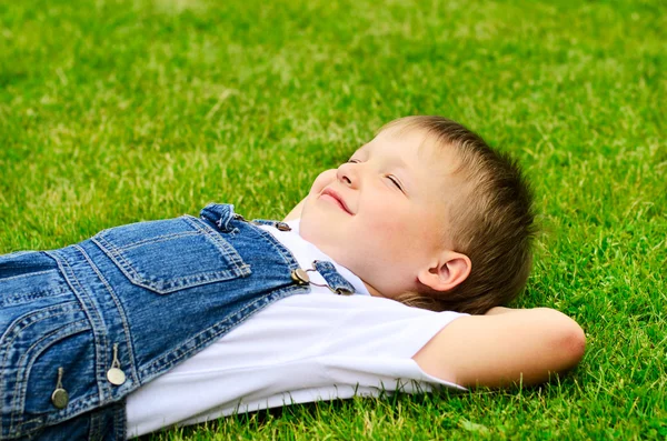 4-летний ребенок лежит на траве . — стоковое фото