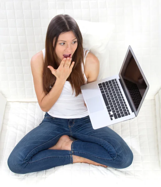 Mujer sentada en un sofá con un portátil moderno escribiendo en el teclado — Foto de Stock