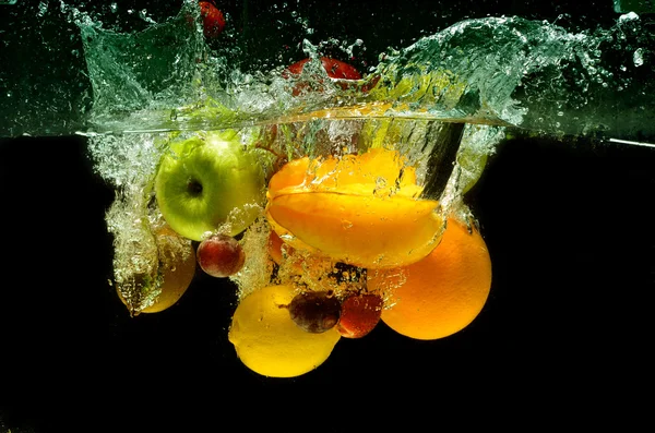 Frisches Obst spritzt ins Wasser — Stockfoto