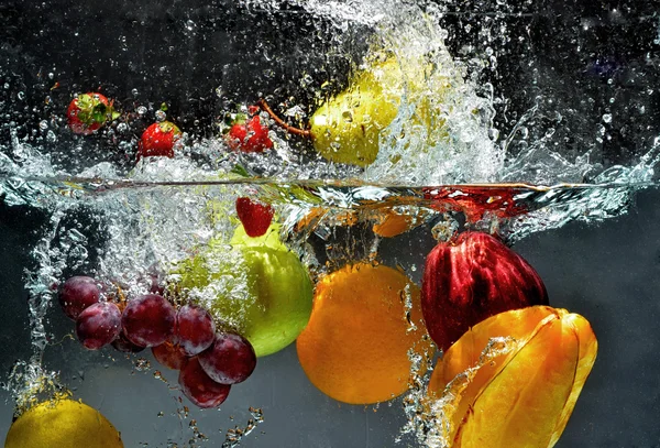 Färsk frukt stänk i vatten Stockbild