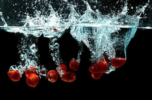 Erdbeerfrucht spritzt auf Wasser — Stockfoto