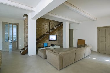 Modern living room with staircase and concrete floor