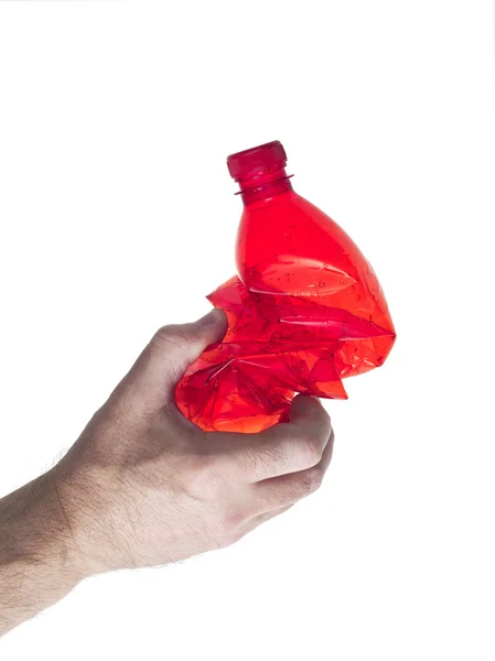 Hand of man holding red plastic bottle crushed — Stock Photo, Image