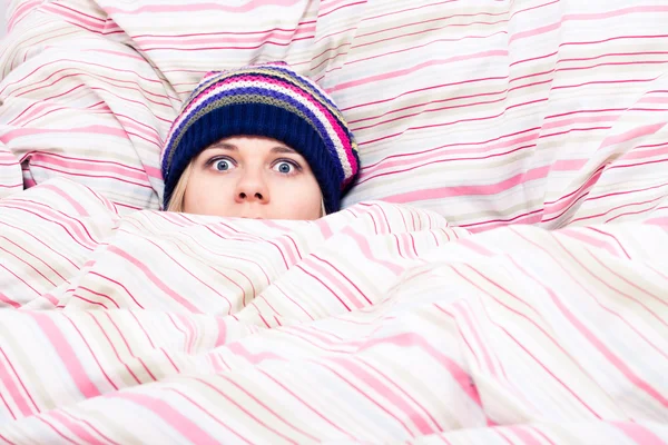 Verängstigte Frau versteckt sich in Bettdecke — Stockfoto