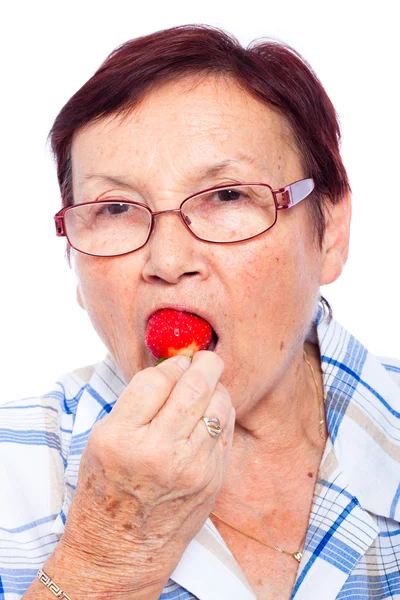 Starszy kobieta jedzenie truskawek — Zdjęcie stockowe