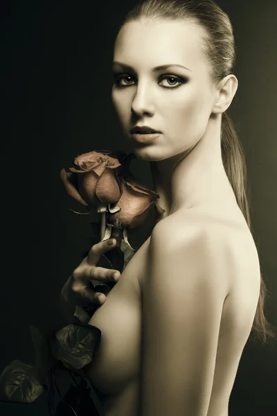 Gilr's low key portrait with roses in the right hand — Stock Photo, Image