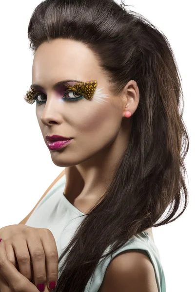 Hübsche Brünette mit gefiedertem Make-up schaut in die Linse — Stockfoto