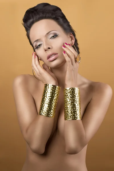 Προκλητικό brunette με δύο χρυσά βραχιόλια, με τα χέρια κοντά απέναν — Φωτογραφία Αρχείου