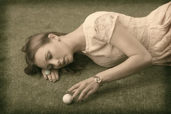 女孩躺在草地上，高尔夫球场球，她命中 — 图库照片