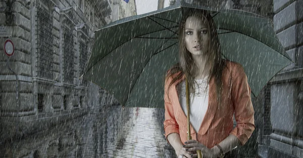 Красивая женщина с зонтиком под дождем — стоковое фото