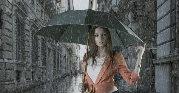 Όμορφη γυναίκα με ομπρέλα στην πόλη υπό βροχή — Φωτογραφία Αρχείου
