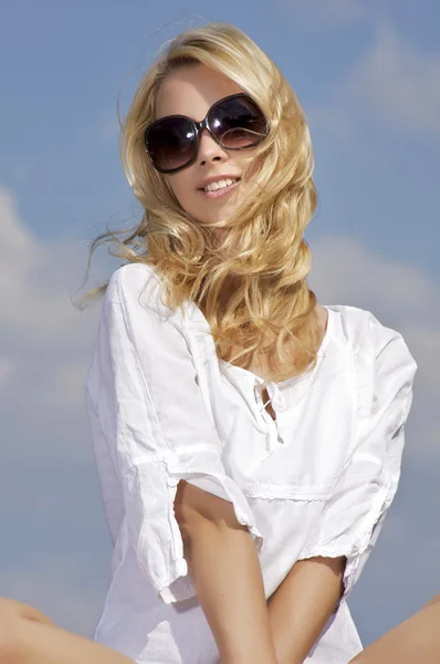 Schönes Mädchen mit Sonnenbrille auf blauem Himmel — Stockfoto