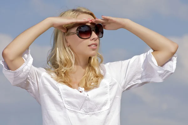 Beautiful girl in sunglasses on background blue sky Royalty Free Stock Images