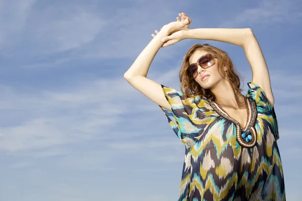Beautiful girl in sunglasses on background blue sky Stock Image