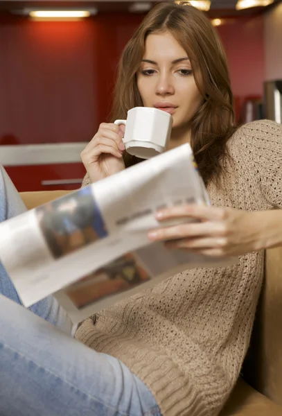 Mid adult woman drinking coffee and reading news — Stock Photo, Image
