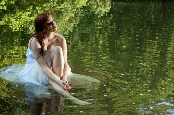 Piękna panna młoda siedzi w wodzie — Zdjęcie stockowe