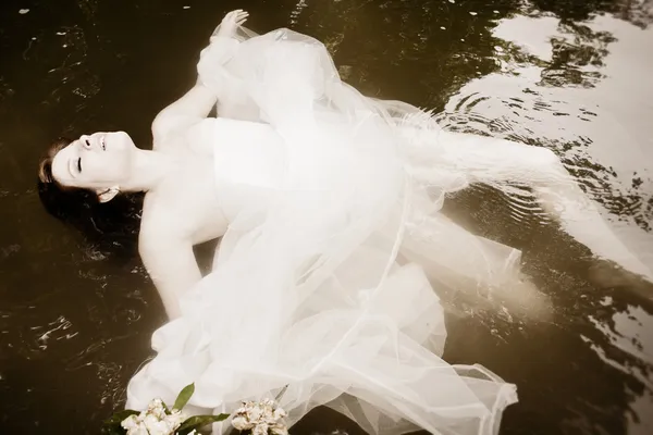 Bride floating in the water — Stock Photo, Image