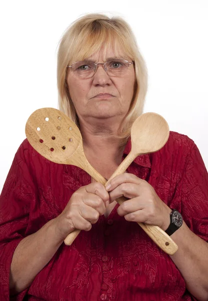 Ältere blonde Frau mit Kochlöffeln — Stockfoto