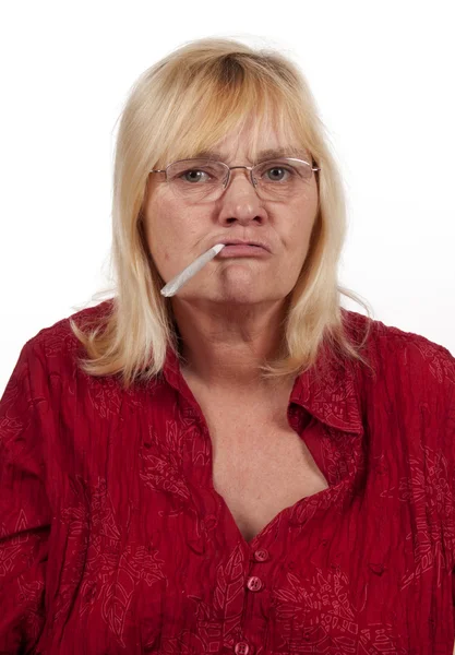 Ältere blonde Frau raucht weat — Stockfoto