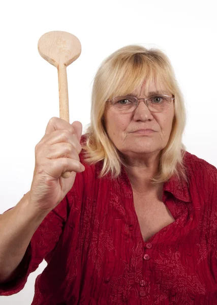 Ältere blonde Frau mit einem Kochlöffel — Stockfoto