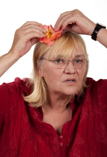 Ältere blonde Frau mit einer Rose — Stockfoto