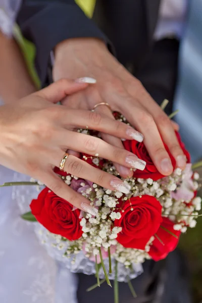 Ruce snubní prsteny a svatební kytice — Stock fotografie