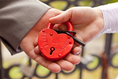 The lock in hands of the groom and the bride clipart