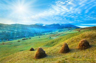 Morning in mountain with sunshine and haystack clipart