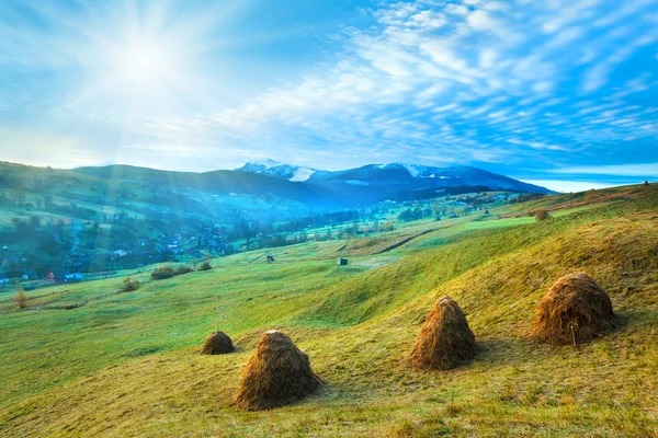 Morning in mountain with sunshine and haystack — Stock Photo, Image