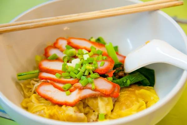 Яичная китайская сухая лапша с жареной красной свининой, пельменями и овощами — стоковое фото