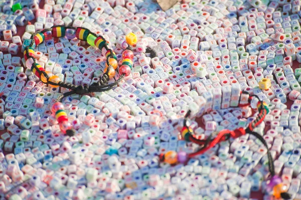 Strukturer av färgglada plast armband på många brev plast cubic, nepal. — Stockfoto