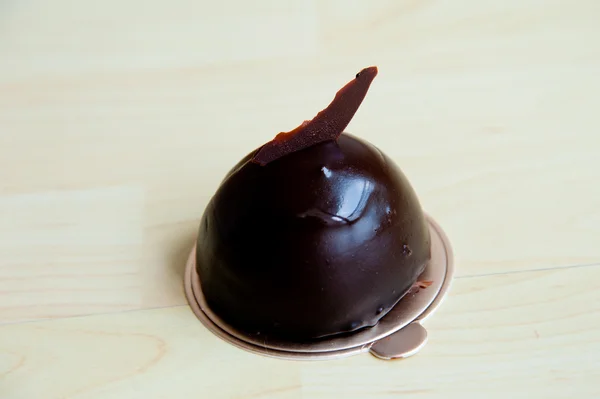Pièce de gâteau sur fond de motif en bois : mousse au chocolat noir extra — Photo