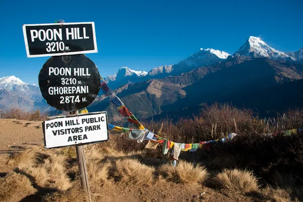 Bela vista do campo de grama, bandeira colorida e montanhas do Himalaia de manhã quando ver a partir do topo do pico Poonhill, Nepal Imagens De Bancos De Imagens Sem Royalties