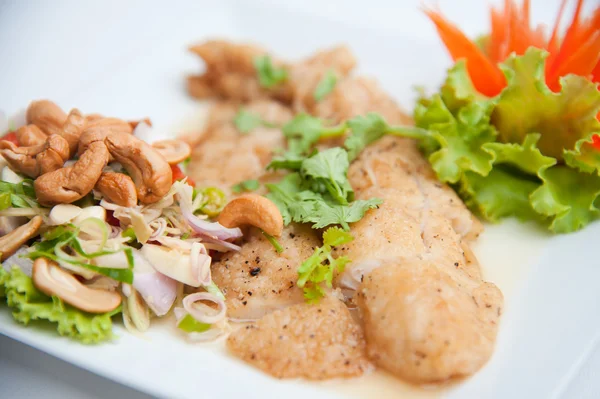 Жареная рыба подается с острым салатом и овощами — стоковое фото