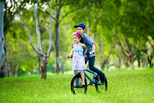 自転車に乗って彼の妹を取る弟 — ストック写真
