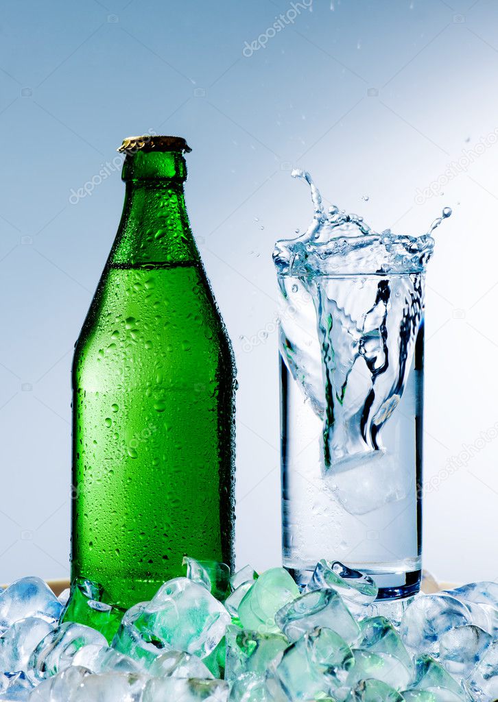 Bottle of mineral water and a glass with ice